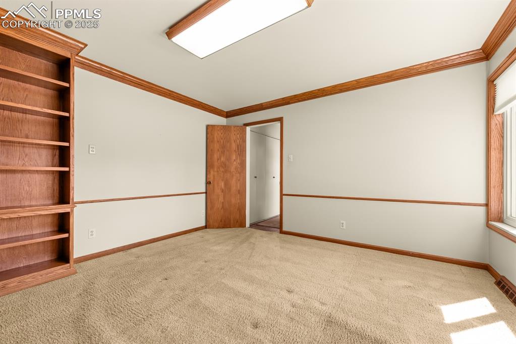 Image 23 of 50: Unfurnished bedroom with crown molding and carpet floors