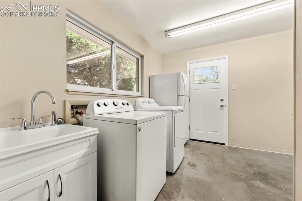Image 24 of 50: Washroom with baseboards and washing machine and clothes dryer