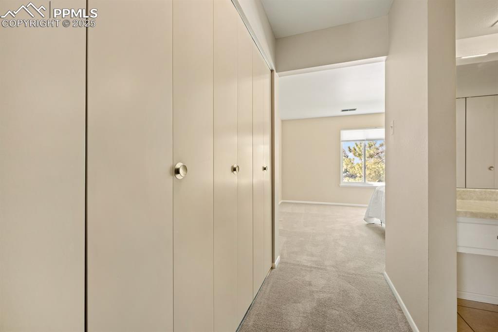 Image 28 of 50: Hallway featuring baseboards and light colored carpet