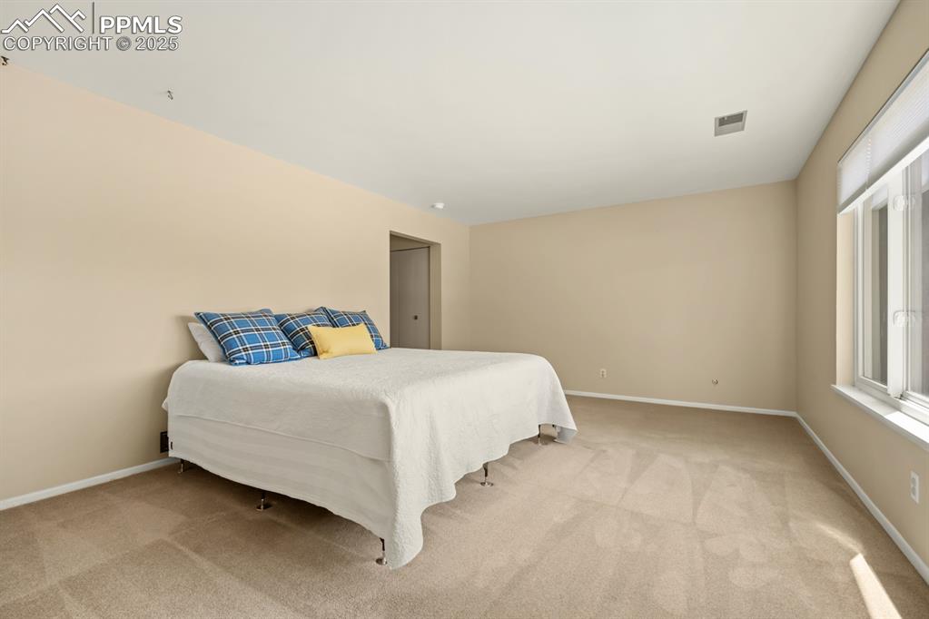Image 30 of 50: Bedroom featuring light carpet and baseboards