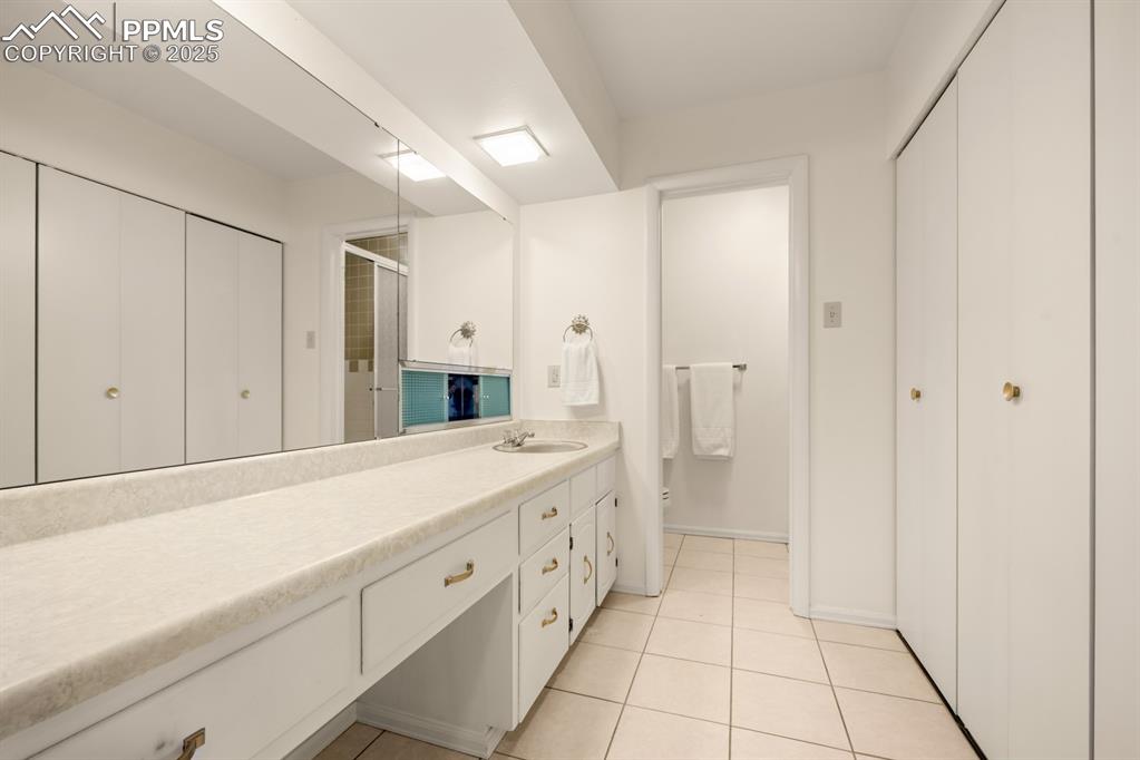 Image 31 of 50: Full bath featuring vanity, a shower stall, light tile patterned floors, an