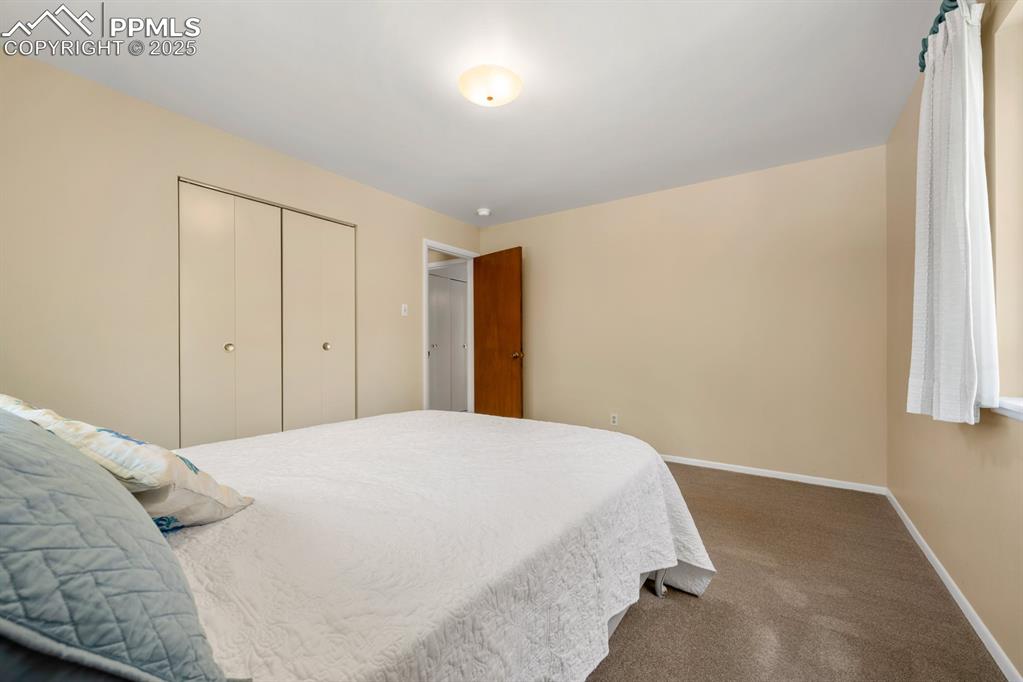 Image 44 of 50: Carpeted bedroom with baseboards and a closet
