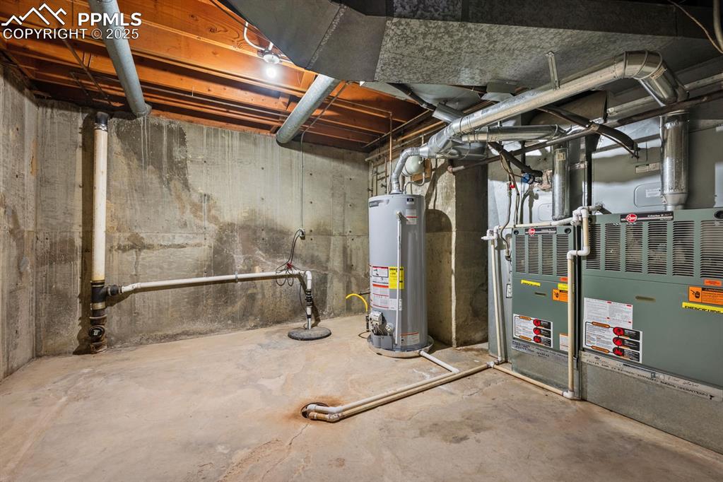 Image 45 of 50: Unfinished below grade area featuring gas water heater, heating unit, and d