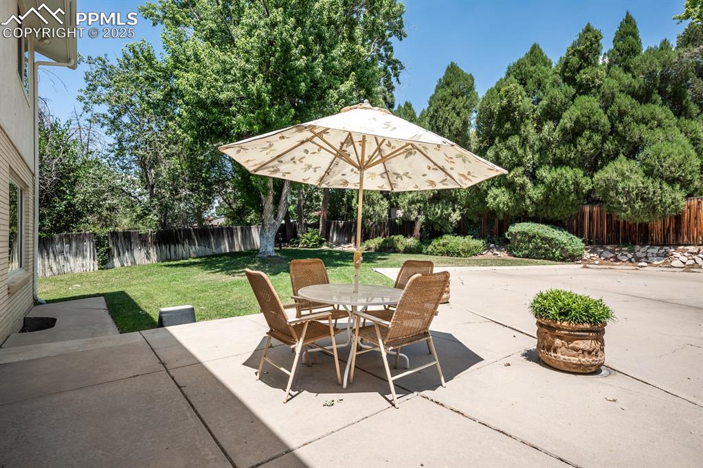 Image 49 of 50: Fenced backyard with a patio and outdoor dining space