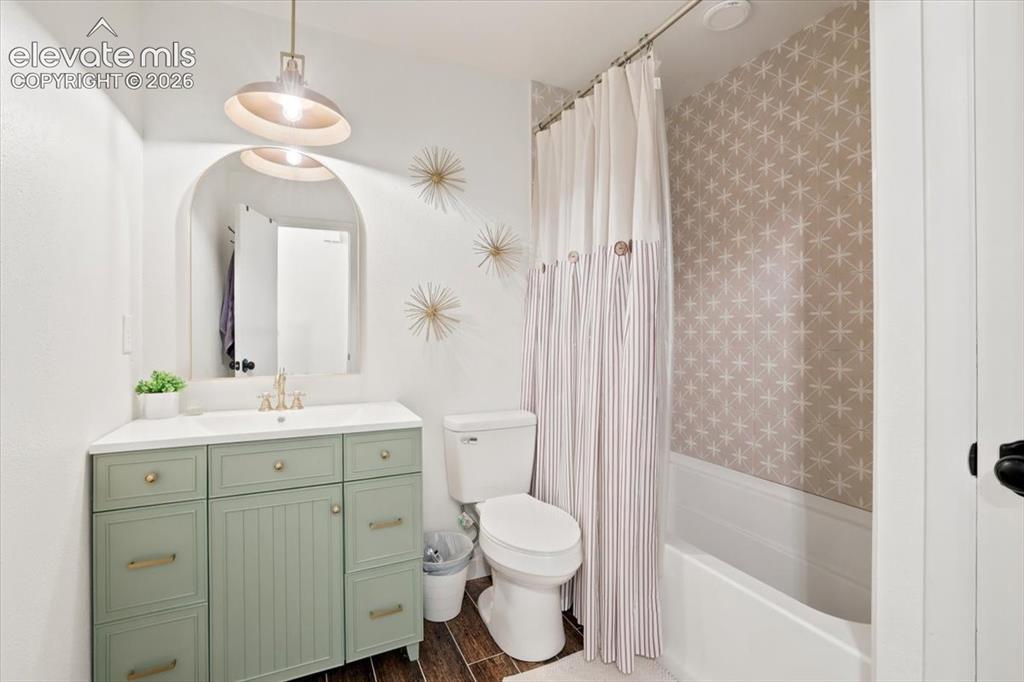 Image 26 of 45: Bathroom featuring a sage green vanity with a white countertop and brass ha