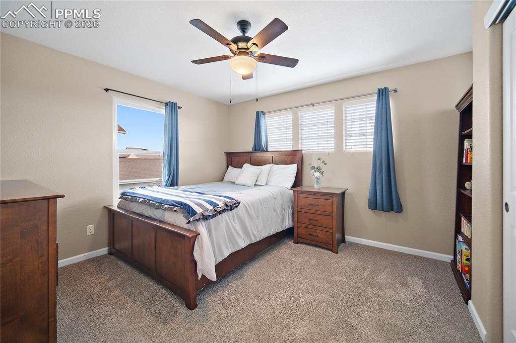 Image 24 of 48: Upstairs bedroom with good amount of natural light, carpet, and ceiling fan
