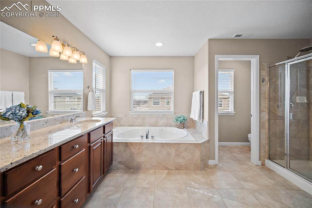 Image 29 of 48: Spacious, spa-like primary bath. Walk-shower, soaking tub and double vanity