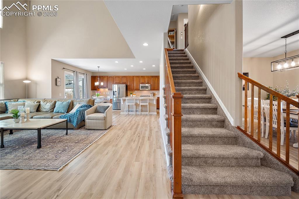 Image 8 of 48: Open concept, 2 story ceiling, wall of windows. Open to the kitchen.