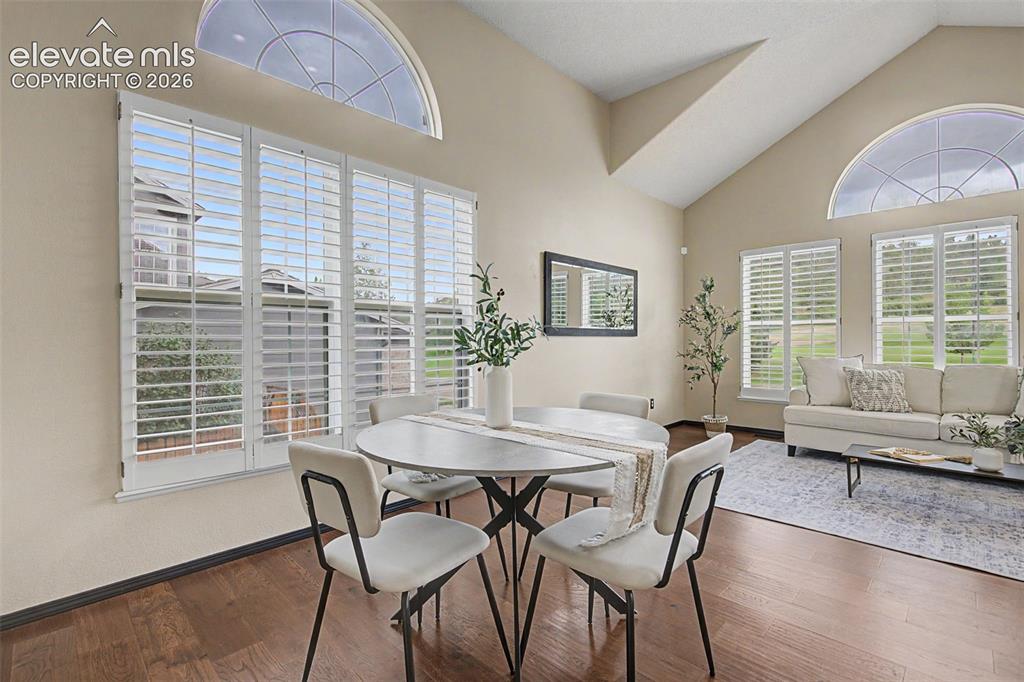 Image 11 of 50: Spacious room featuring vaulted ceilings, rich wood-finish flooring, and mu