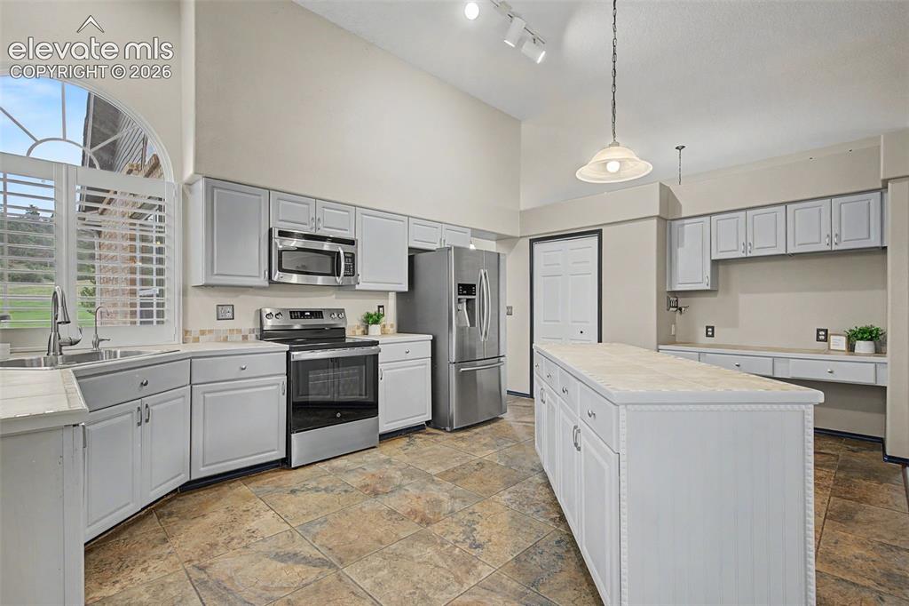 Image 15 of 50: Kitchen featuring a center island, stainless steel appliances, light-painte