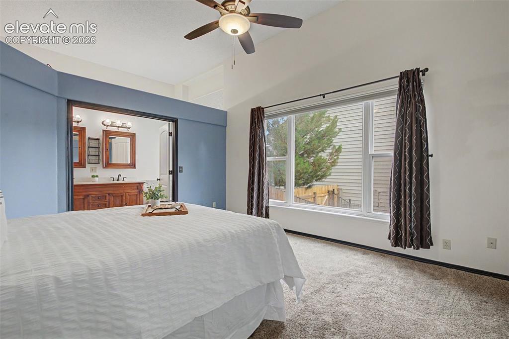 Image 27 of 50: Spacious bedroom featuring vaulted ceilings, a ceiling fan with integrated 