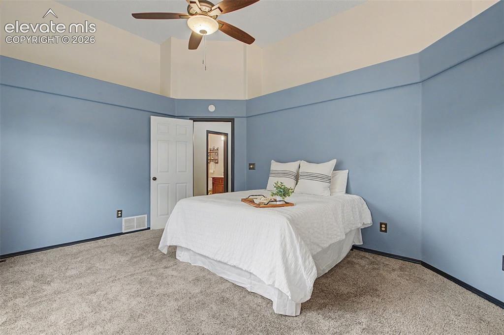 Image 29 of 50: Bedroom featuring a ceiling fan with integrated lighting, a vaulted ceiling