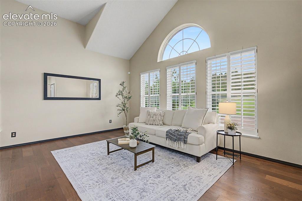 Image 3 of 50: Living space featuring high vaulted ceilings, rich wood-finish flooring, an