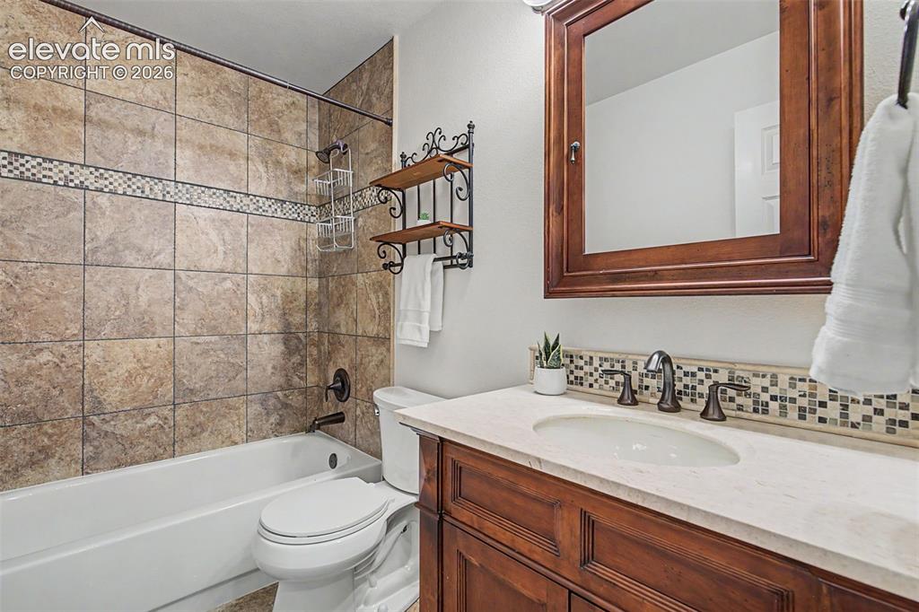 Image 33 of 50: Bathroom featuring a white tub, shower with large format tile surround and 