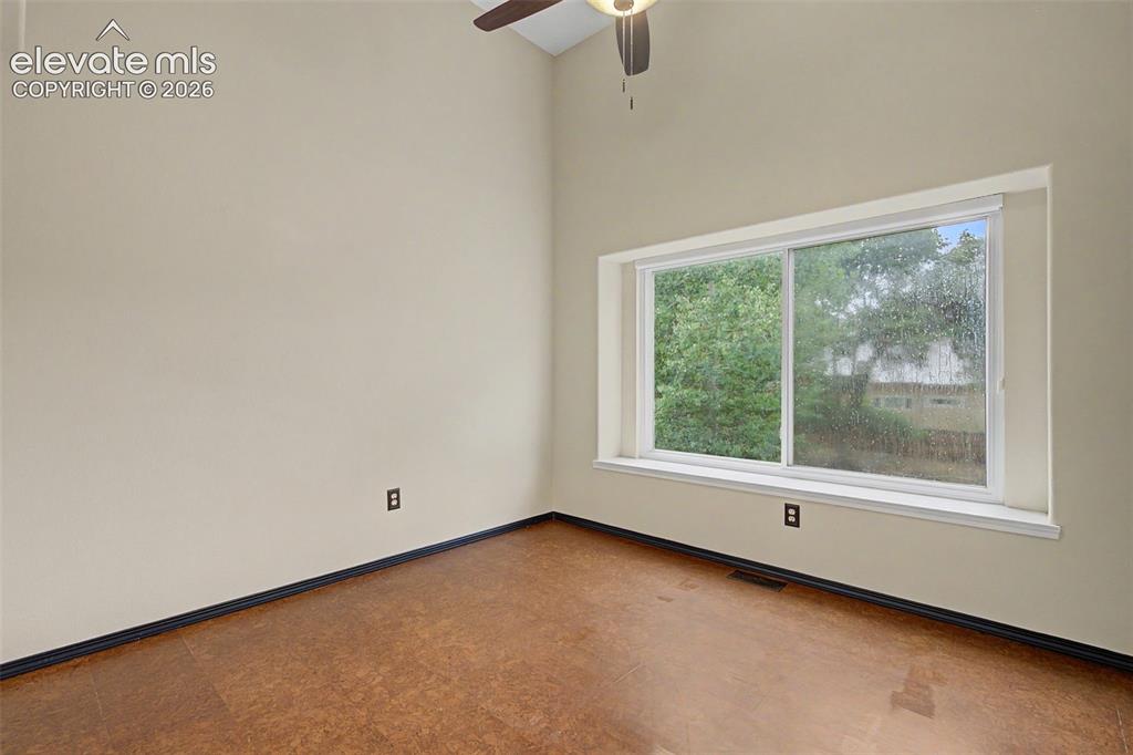 Image 34 of 50: Room featuring a vaulted ceiling and a ceiling fan with integrated lighting