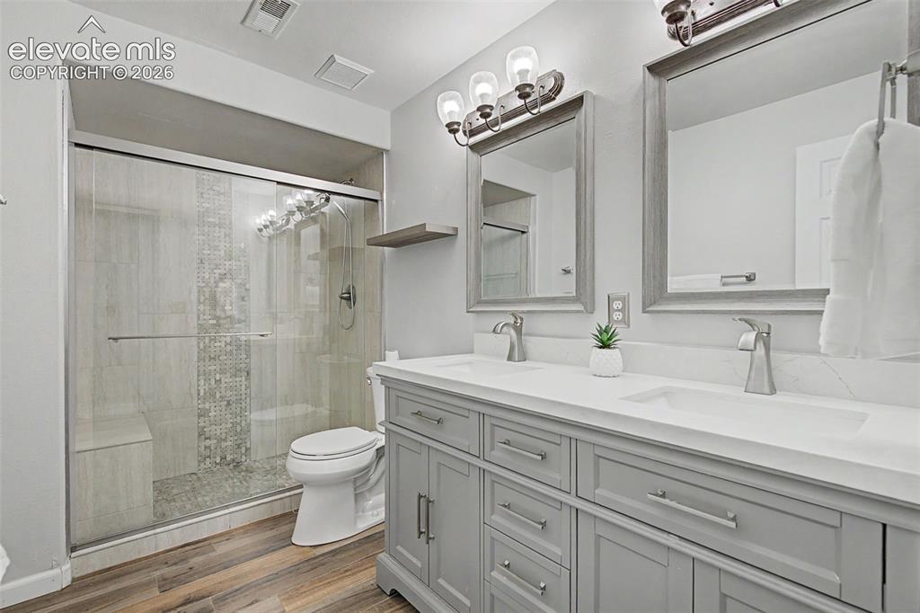 Image 42 of 50: Bathroom featuring a double vanity with light gray cabinetry, white counter