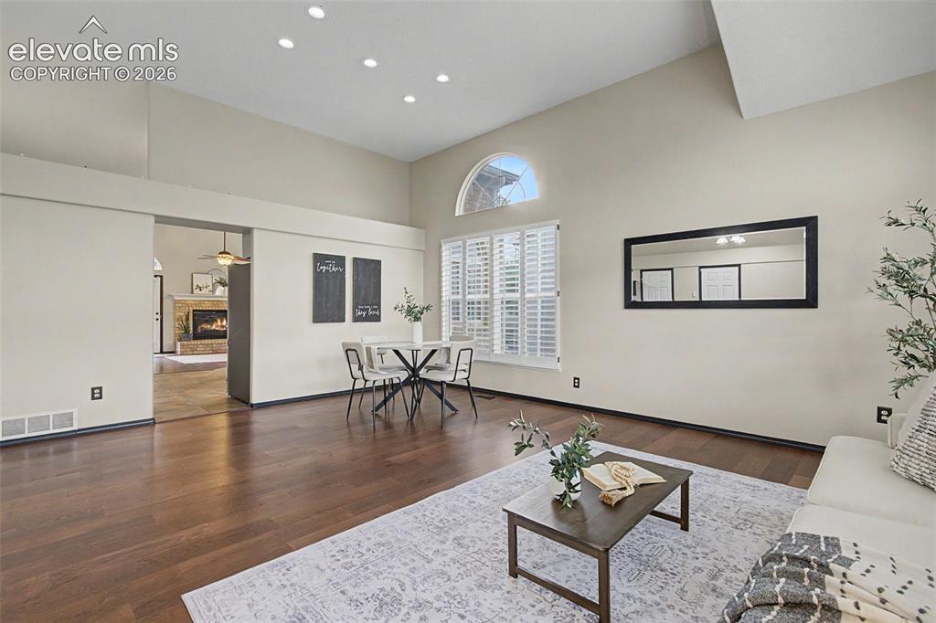 Image 7 of 50: Spacious interior featuring high ceilings with recessed lighting, wood-fini