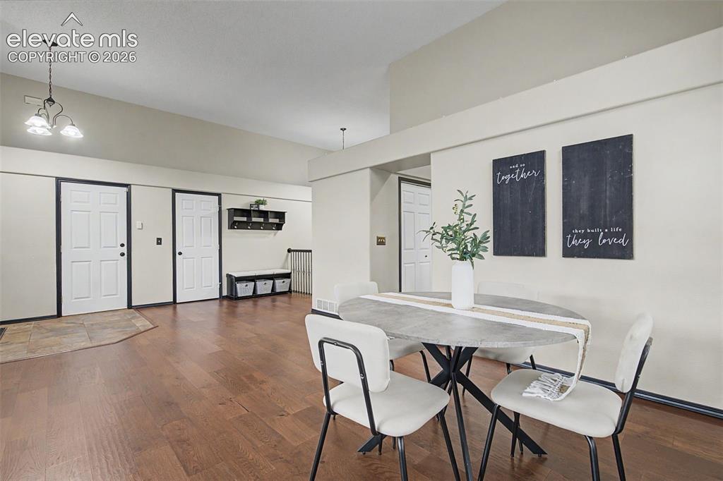 Image 9 of 50: Spacious open-concept room featuring wood-finish flooring, vaulted ceilings