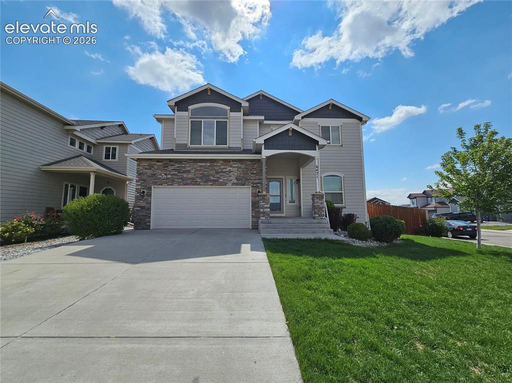 Caption: Two-story residence featuring a stone and siding facade, an attached two-car garage, and a covered f
