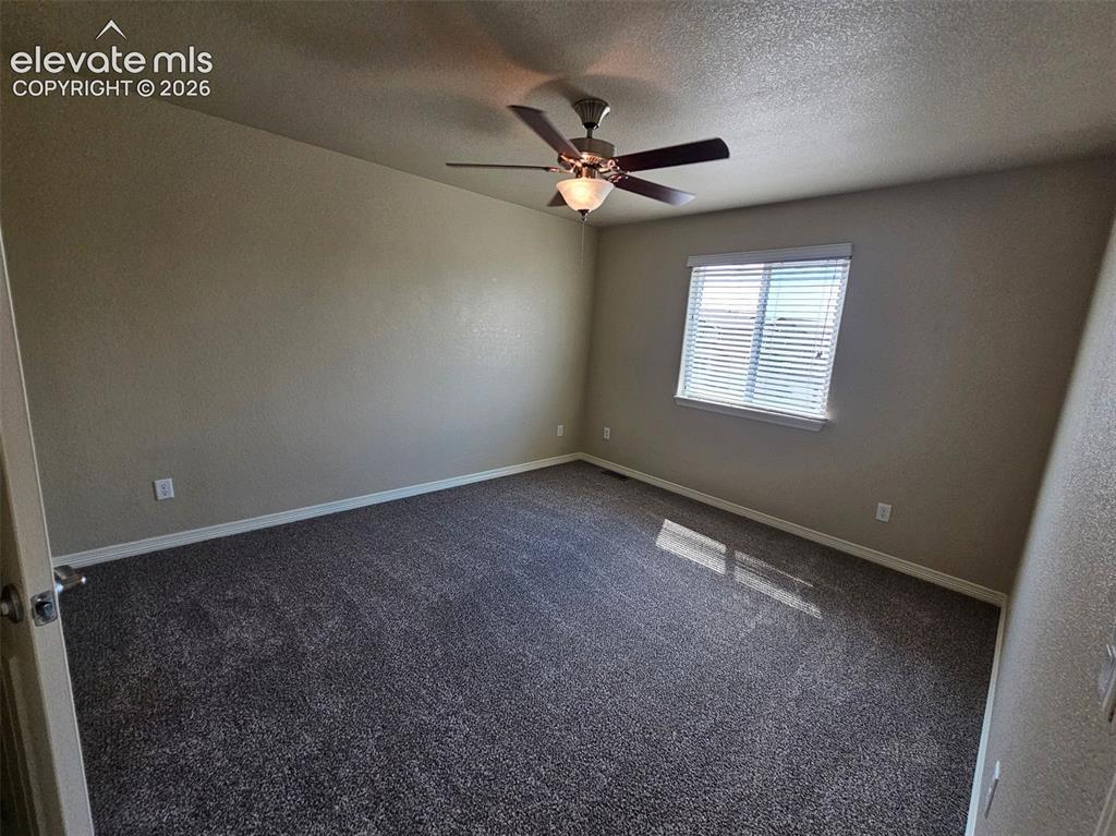 Image 11 of 31: Carpeted room featuring a ceiling fan with integrated lighting, neutral wal