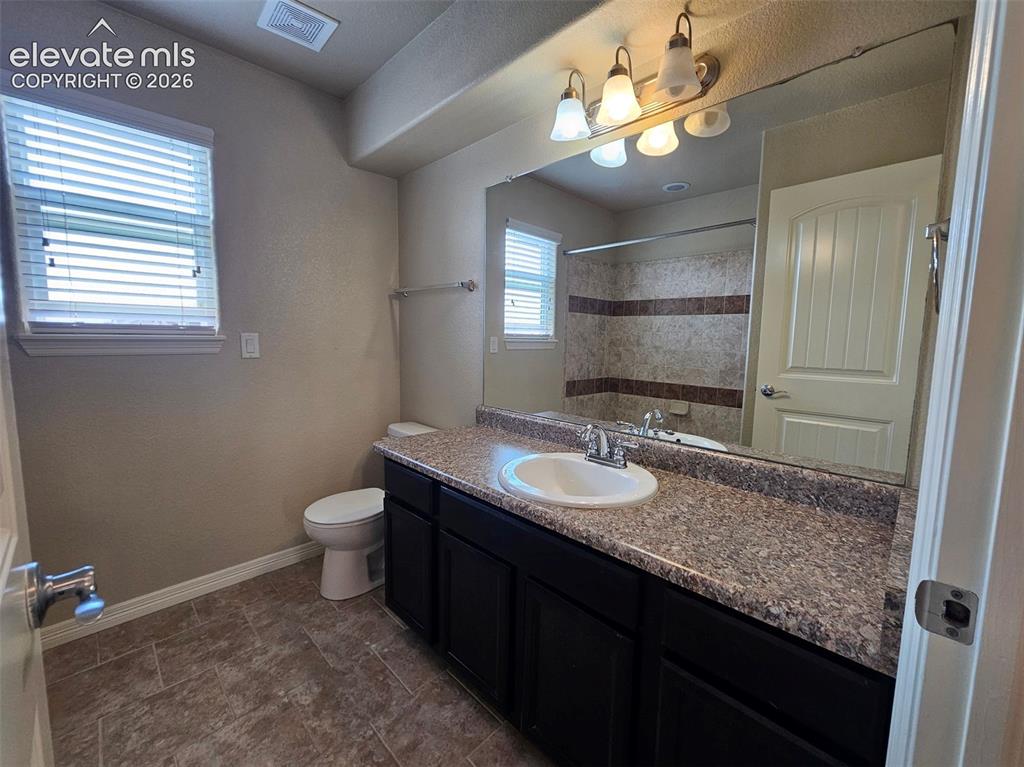 Image 13 of 31: Bathroom featuring a dark wood-finish vanity with a speckled countertop and