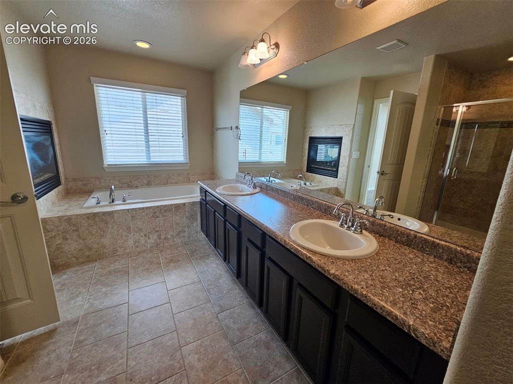 Image 16 of 31: Bathroom featuring a dual vanity with undermount sinks, a large integrated 