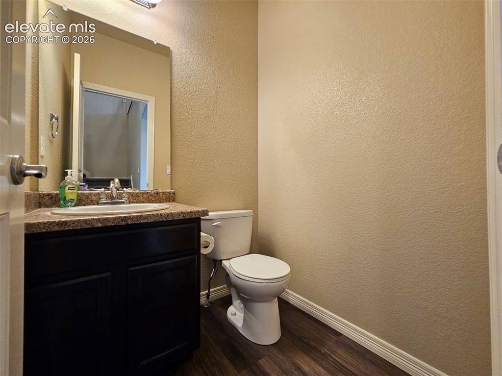 Image 4 of 31: Vanity featuring a stone-finish countertop, undermount sink, and dark wood-