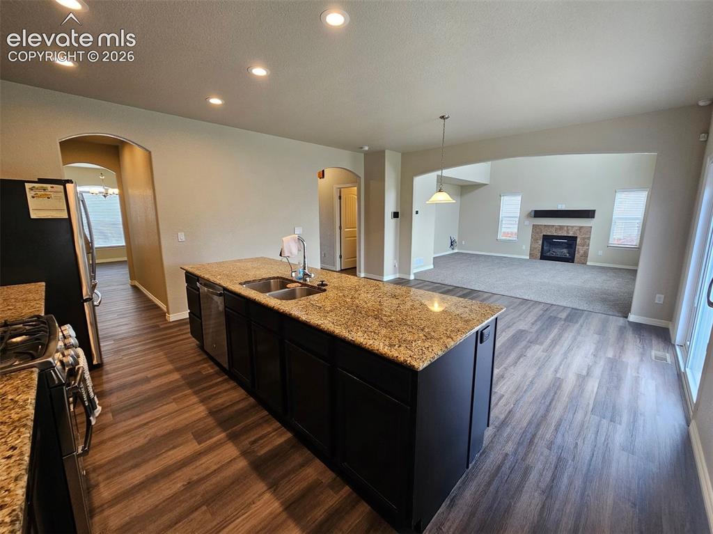 Image 9 of 31: Kitchen island with a double basin sink and a granite-style countertop