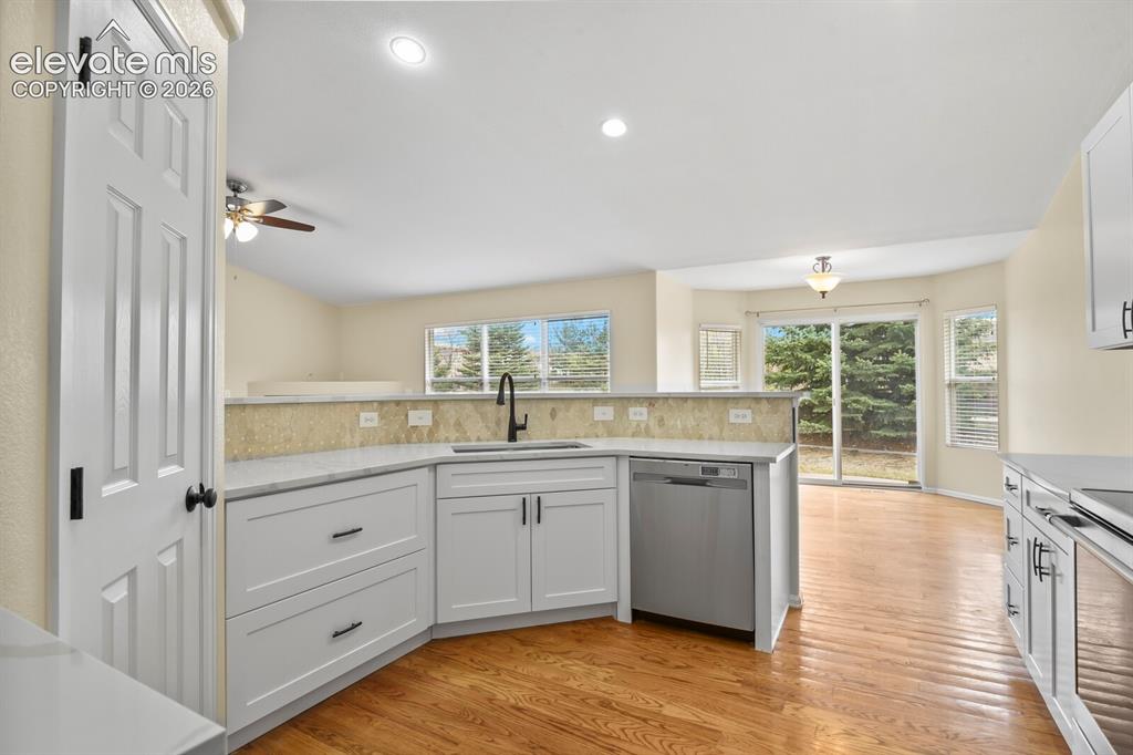 Image 14 of 48: Contemporary kitchen featuring white cabinetry, light-colored countertops,