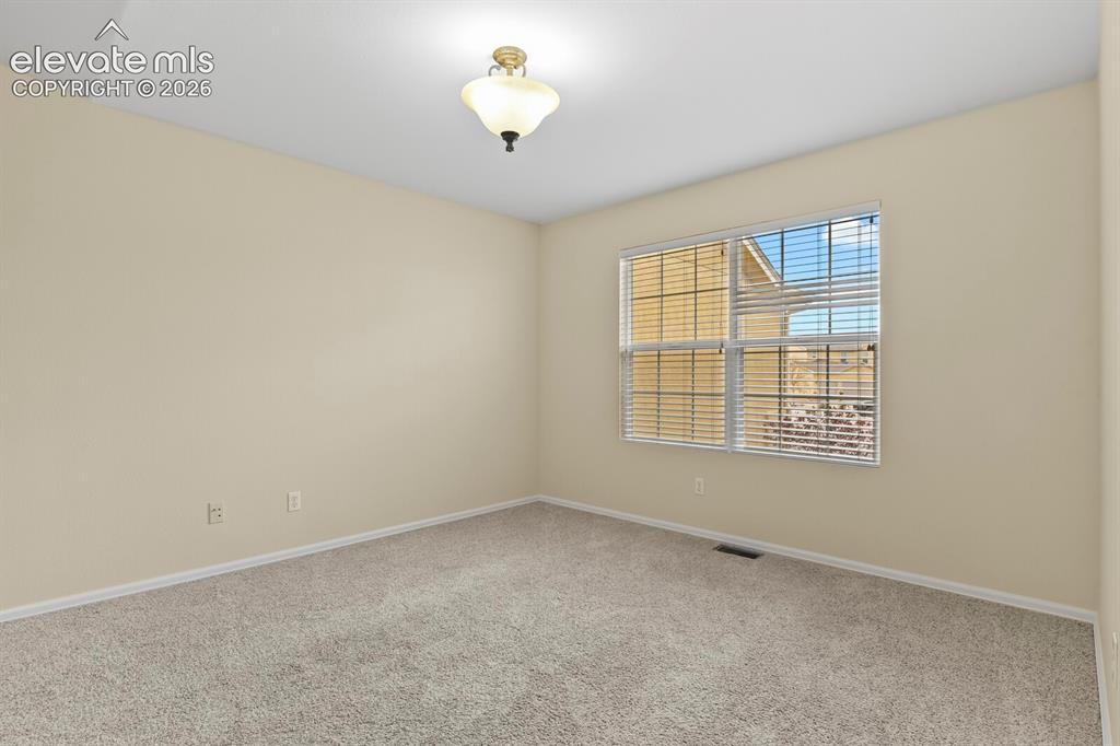 Image 17 of 48: Inviting room featuring a large window with blinds, neutral-toned walls, pl
