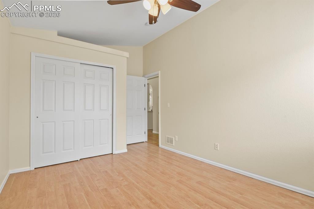 Image 24 of 43: Spacious room featuring vaulted ceilings, wood-finish flooring, a ceiling f