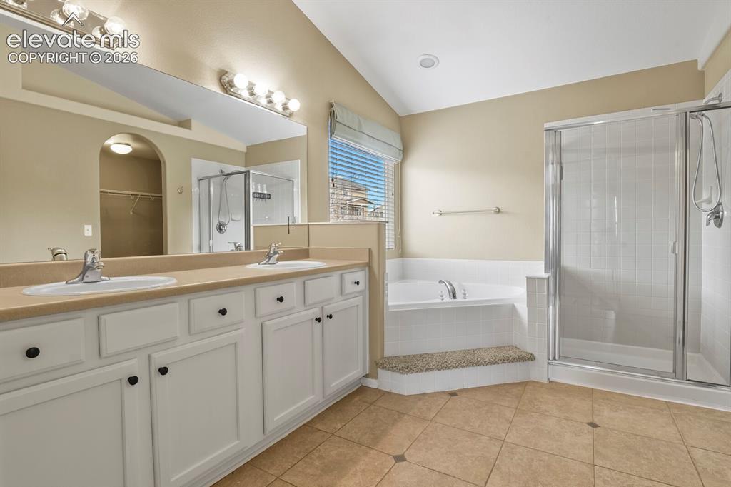 Image 24 of 48: Dual sink vanity with white cabinetry and dark hardware, Warming Tile Floor