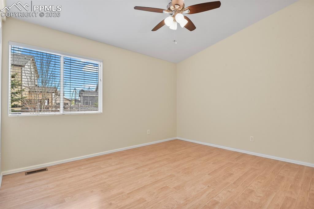 Image 26 of 43: Spacious room featuring vaulted ceilings, a ceiling fan with integrated lig