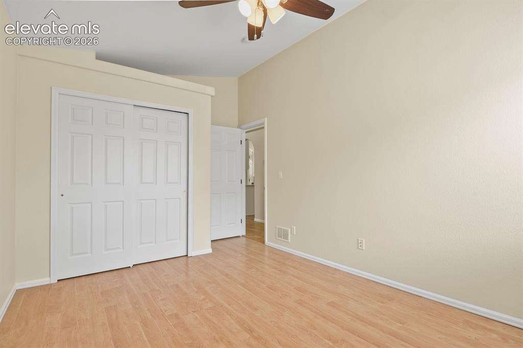 Image 27 of 48: Spacious room featuring vaulted ceilings, wood-finish flooring, a ceiling f