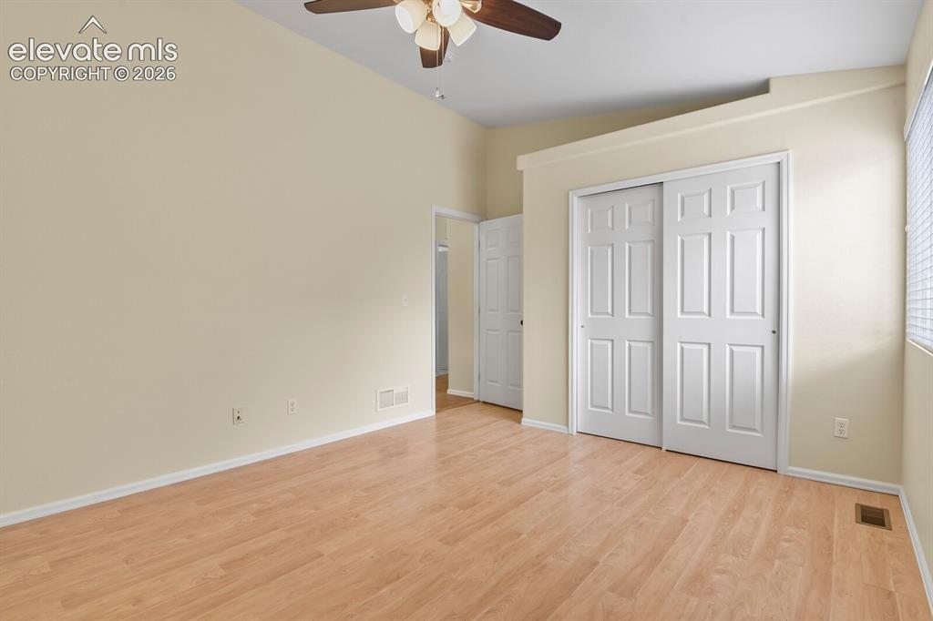Image 30 of 48: Spacious room featuring vaulted ceilings, wood-finish flooring, a ceiling f