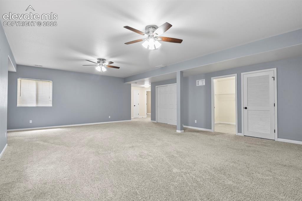 Image 34 of 48: Spacious room featuring light beige carpeting, neutral wall paint, and two