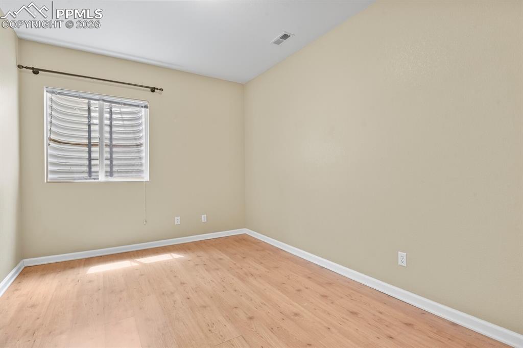 Image 36 of 43: Room featuring wood-finish flooring, a neutral wall palette, white baseboar