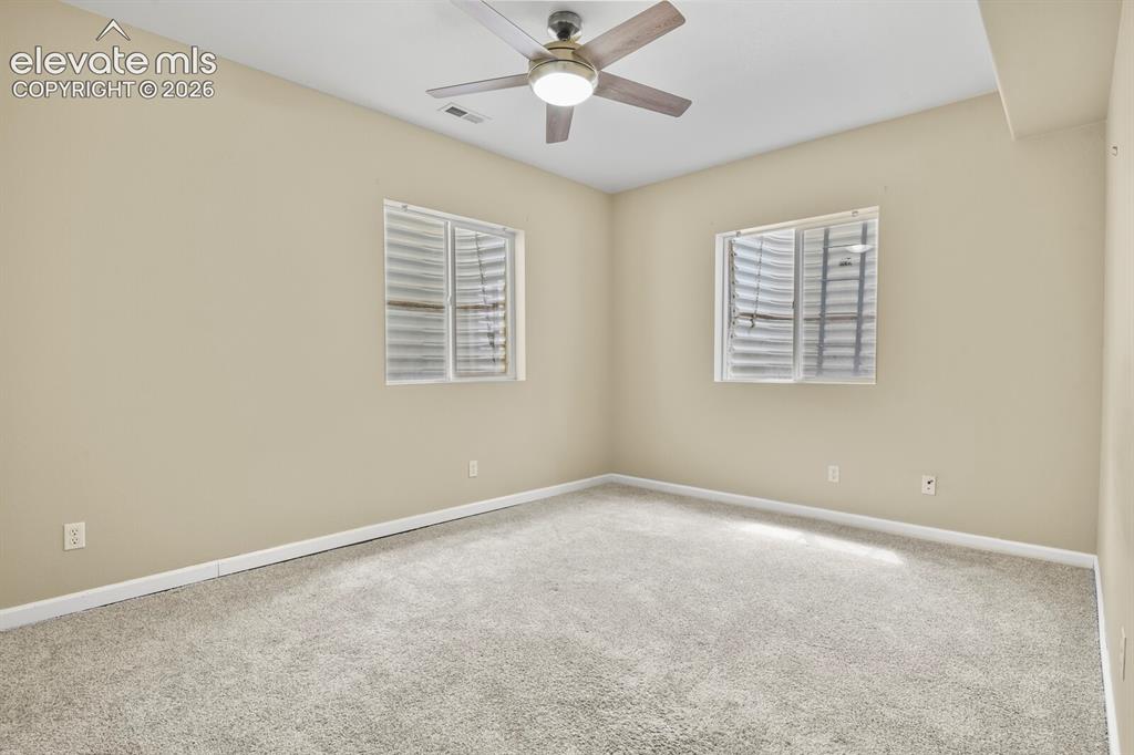 Image 37 of 48: Spacious room featuring neutral carpeting, light-toned wall paint, two wind