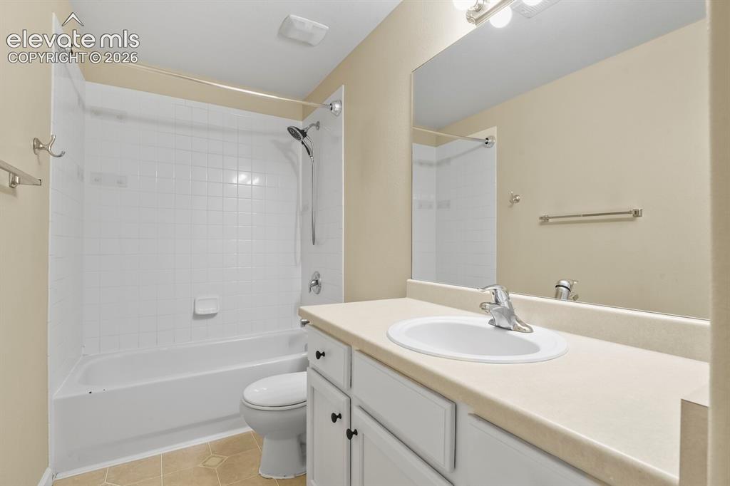 Image 39 of 48: Bathroom featuring a white vanity with an integrated sink, a large wall-mou