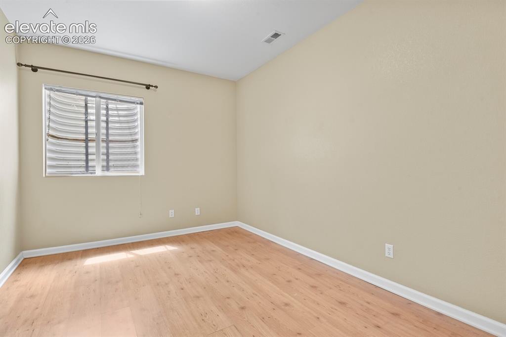 Image 40 of 48: Room featuring wood-finish flooring, a neutral wall palette, white baseboar