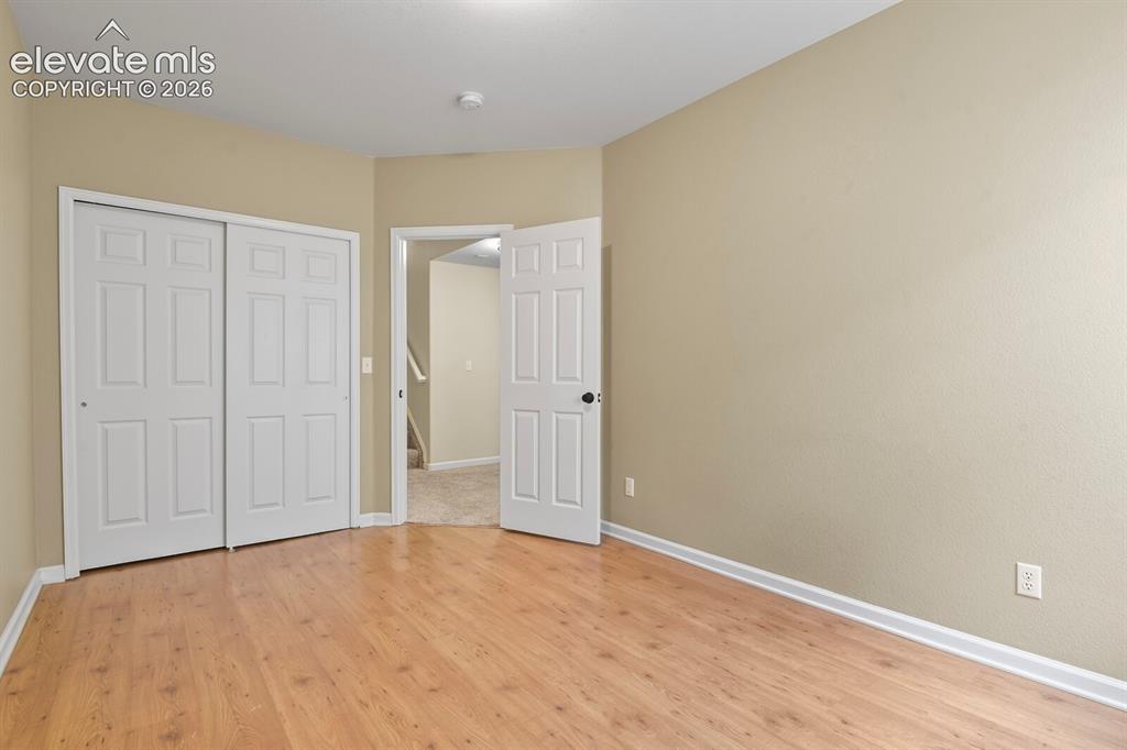 Image 41 of 48: Room featuring wood-finish flooring, neutral wall paint, and white trim