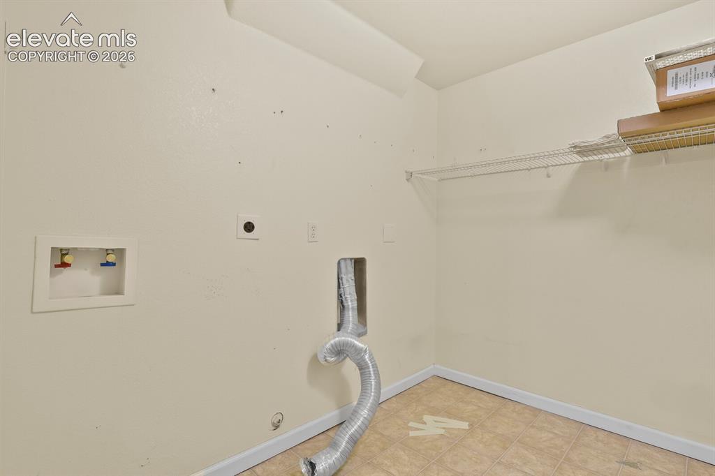 Image 42 of 48: Utility area featuring tile flooring, and white wire shelf