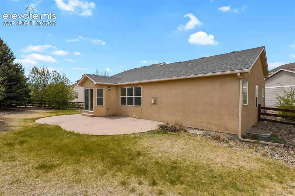 Image 44 of 48: Expansive backyard featuring a curved concrete patio, stucco exterior, mult