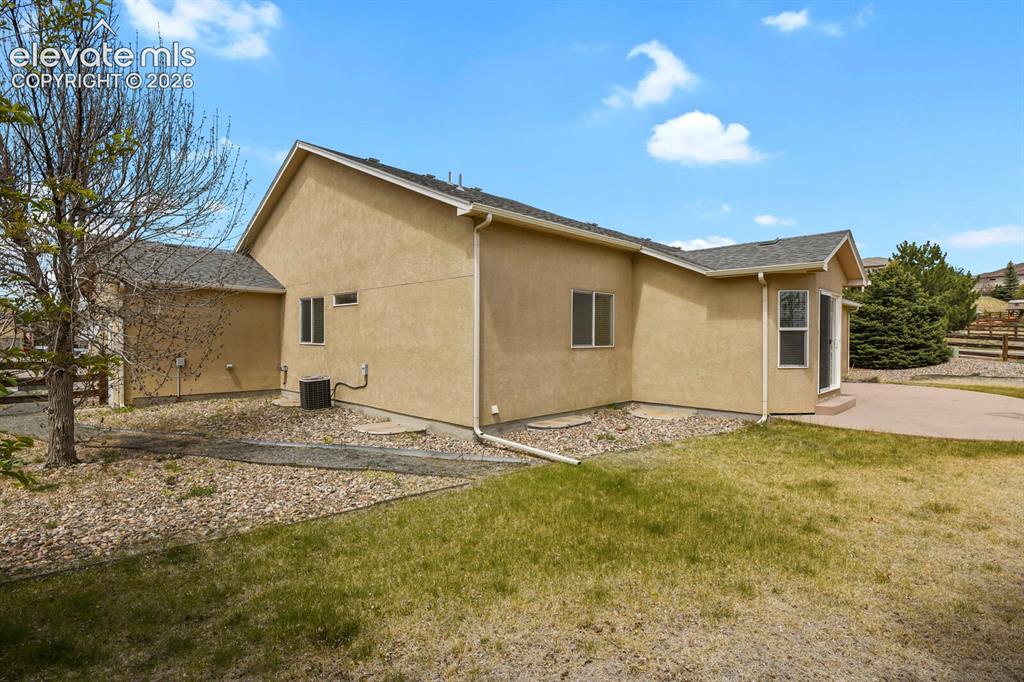 Image 47 of 48: Stucco exterior featuring multiple windows and a curved patio