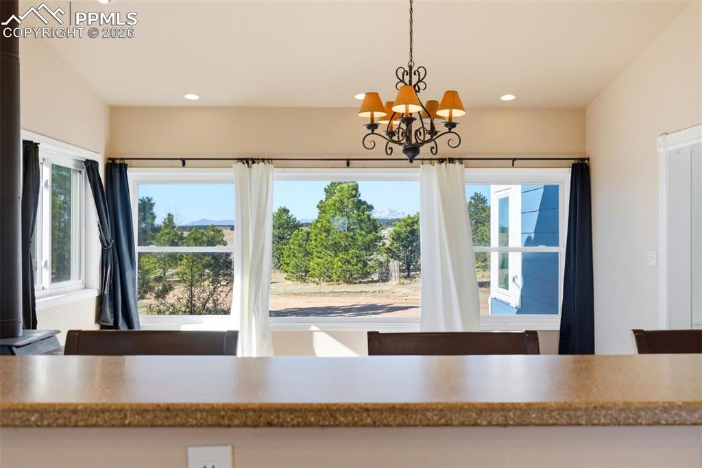 Image 11 of 50: Dining area with a chandelier and views of Pikes Peak