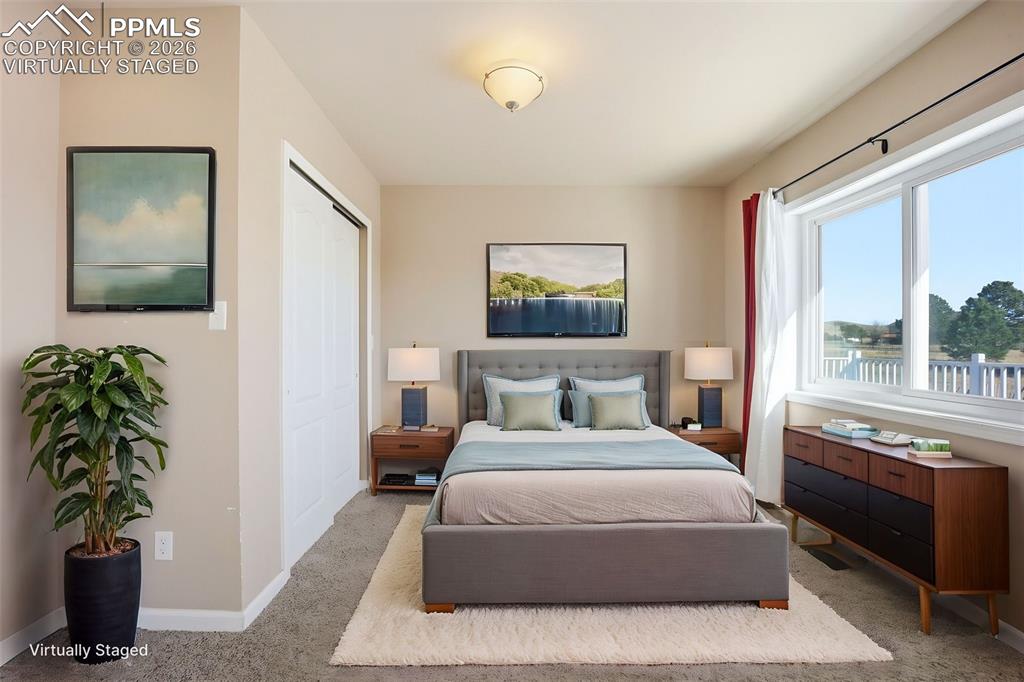 Image 13 of 50: Virtually staged main level bedroom or office, with a closet and carpet