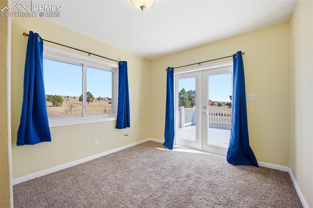 Image 16 of 50: 2nd main level bedroom, with french doors, and lots of light