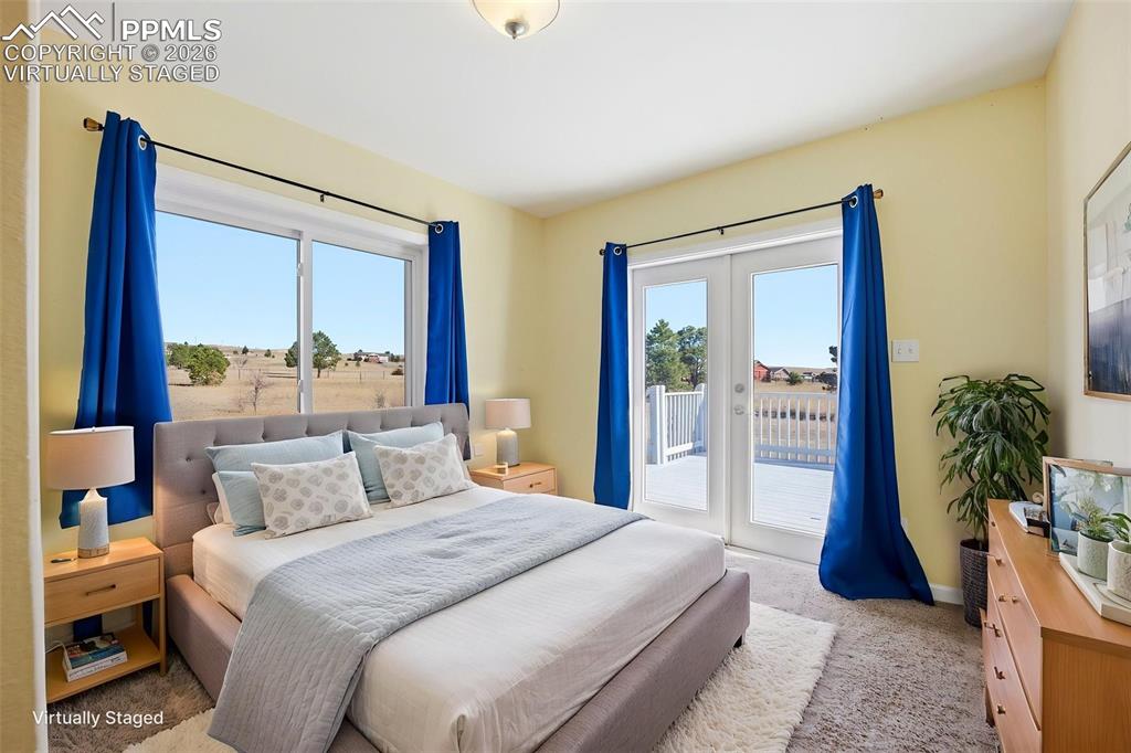 Image 17 of 50: Virtually staged 2nd main level bedroom, with french doors, and lots of lig