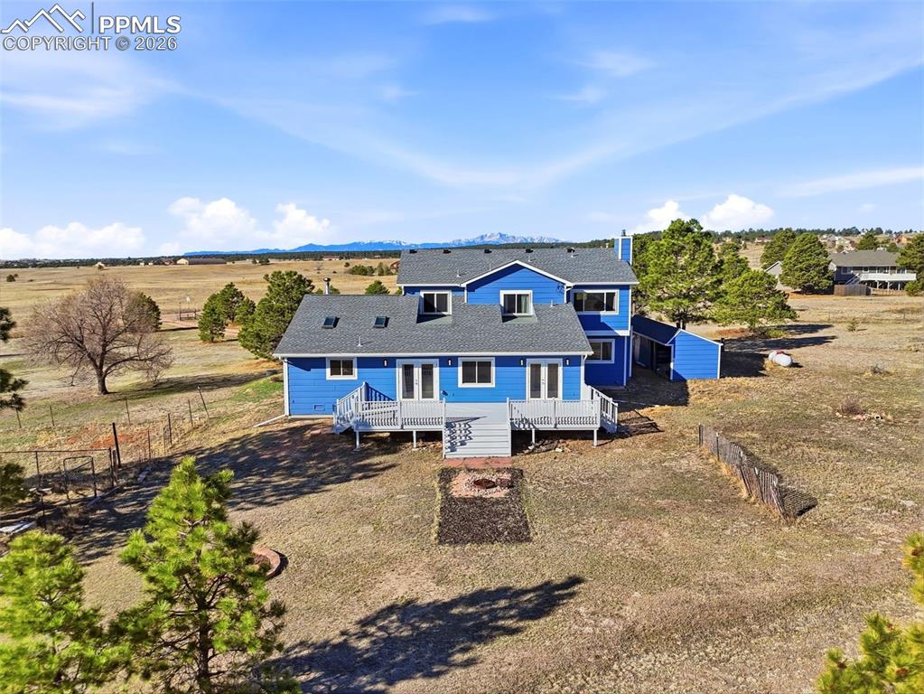 Image 2 of 50: Back of house featuring a deck and clear views of Pikes Peak