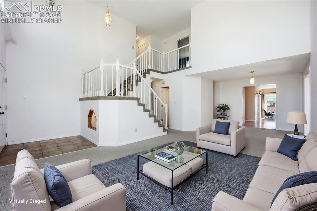 Image 22 of 50: Virtually staged living room with a high vaulted ceiling